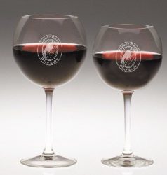 Two wine glasses with red wine, etched with the logo "Forest City Golf Club," on a neutral background. One glass is slightly taller than the other.
